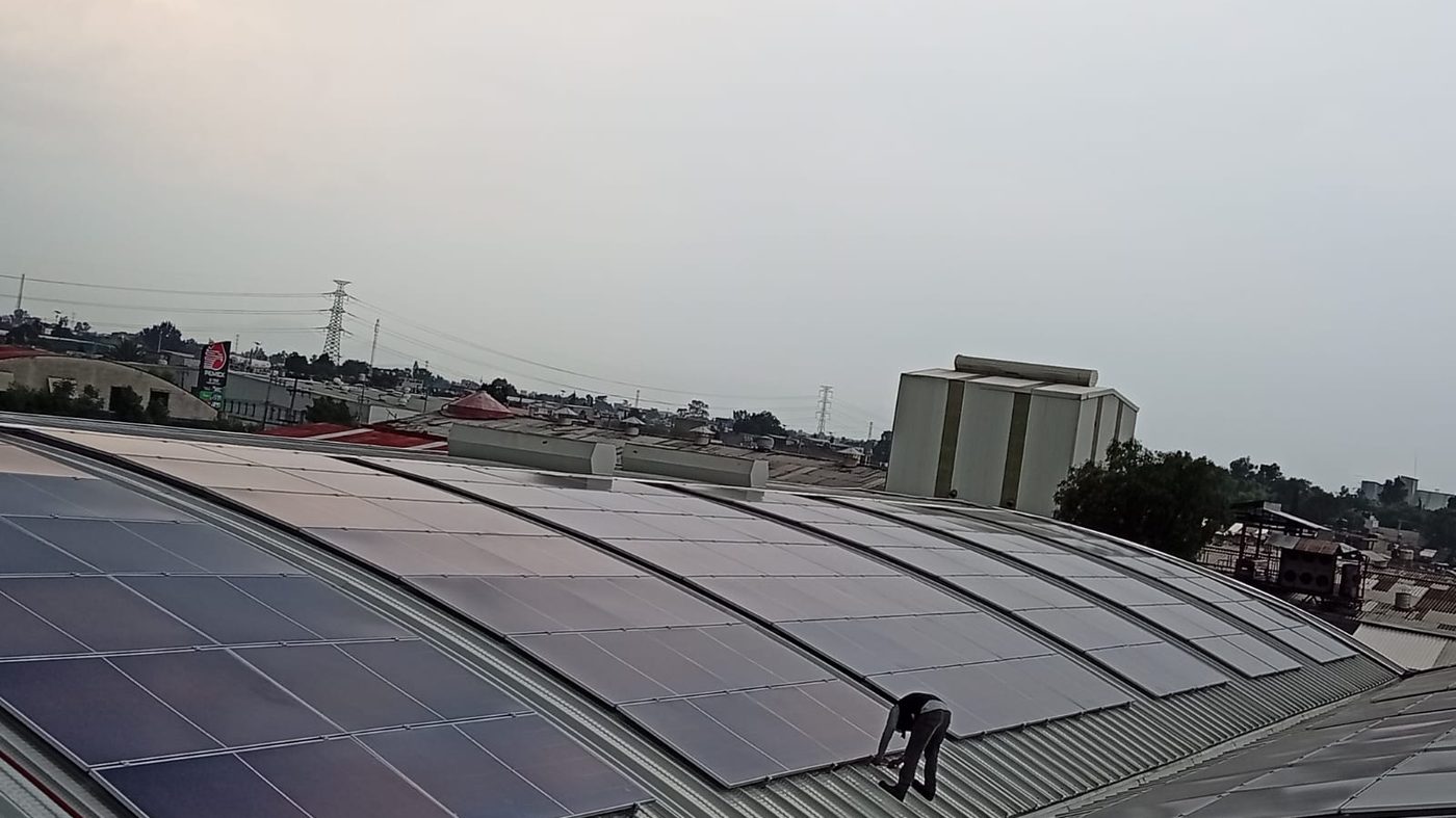 Paneles solares montados sobre techo de lámina curva en nave industrial